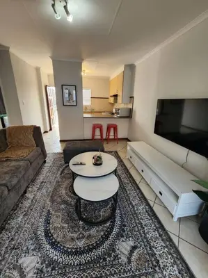 a living room with a couch and a table at 56 - Elegant 2 bed apartment next to Gautrain Centurion in Centurion