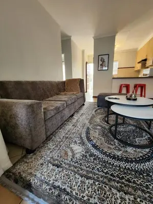 a living room with a couch and a table at 56 - Elegant 2 bed apartment next to Gautrain Centurion in Centurion