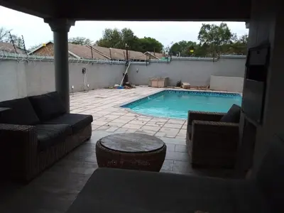 a swimming pool with a couch and chairs and a table at MOK villa holiday home in Hazyview