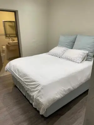 a large bed with white sheets and blue pillows at MOK villa holiday home in Hazyview