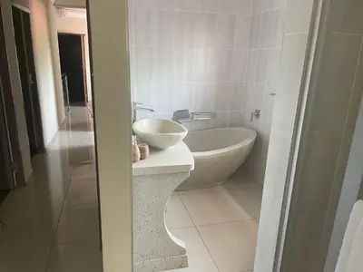 a white bathroom with a sink and a tub at MOK villa holiday home in Hazyview