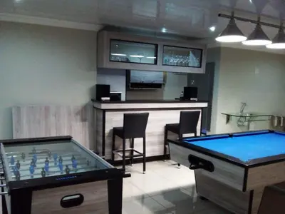 a room with two pool tables and a bar at MOK villa holiday home in Hazyview