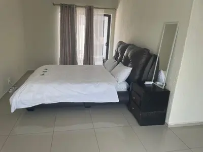 a bedroom with a large bed with a white bedspread at MOK villa holiday home in Hazyview