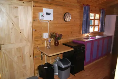 a kitchen with a counter and a table in a room at Fern Cottage in Louis Trichardt
