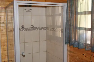 a shower with a glass door in a bathroom at Fern Cottage in Louis Trichardt