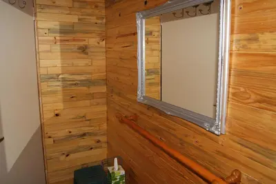 a mirror on a wooden wall in a room at Fern Cottage in Louis Trichardt