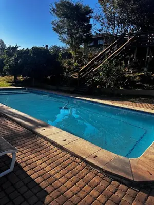 a swimming pool with blue water next to a house at Banabaka spa and venue in White River