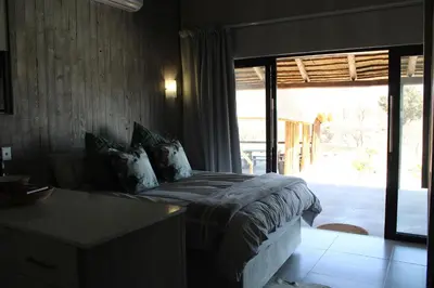 a bedroom with a bed and a sliding glass door at Sharon Lodge in Hammanskraal