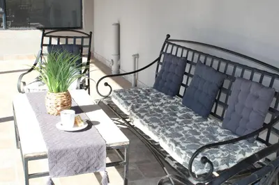 a bench and a table with a plant on a balcony at Sharon Lodge in Hammanskraal