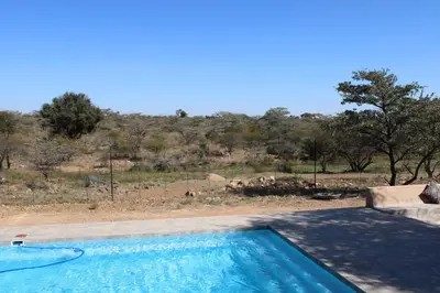 a swimming pool with a view of a field at Sharon Lodge in Hammanskraal