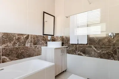 a bathroom with a white tub and a sink at Gosheni Villas in White River