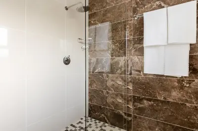 a shower with a glass door in a bathroom at Gosheni Villas in White River