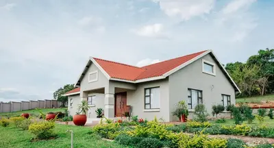 a white house with a red roof at Gosheni Villas in White River