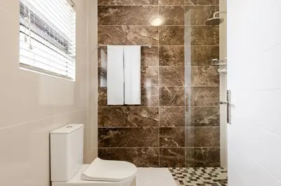 a bathroom with a toilet and a shower at Gosheni Villas in White River