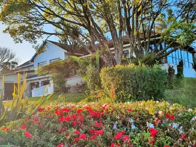 a garden with flowers in front of a house at Paradise View Guesthouse in Graskop