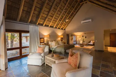 a living room with white couches and a living room with at Simbavati River Sands in Timbavati Game Reserve