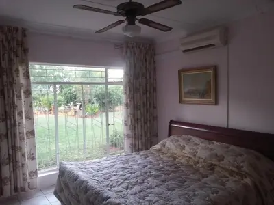 a bedroom with a bed and a large window at Boschfontein Guest Farm in Thabazimbi
