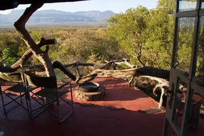 a chair on a porch with a view of the desert at Boschfontein Guest Farm in Thabazimbi