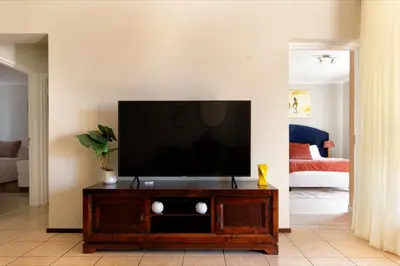 a living room with a flat screen tv on a entertainment center at 82 NOLE 2bed 2 bath apartment in Midrand