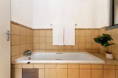 a bath tub in a bathroom with a plant at 82 NOLE 2bed 2 bath apartment in Midrand