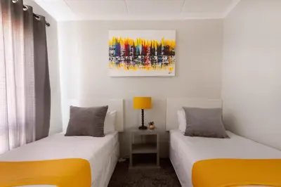 a bedroom with two beds and a painting on the wall at 82 NOLE 2bed 2 bath apartment in Midrand