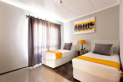 a bedroom with two beds and a window at 82 NOLE 2bed 2 bath apartment in Midrand