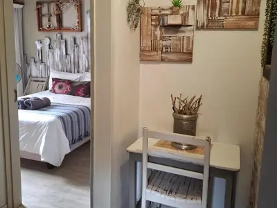 a bedroom with a bed and a table with a chair at SomethingElz@Grace in Pretoria
