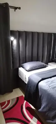 a bedroom with two beds and a leather headboard at Cheers in Evander
