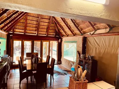 a dining room with a table and chairs at Nyala Luxury Safari Tents in Marloth Park