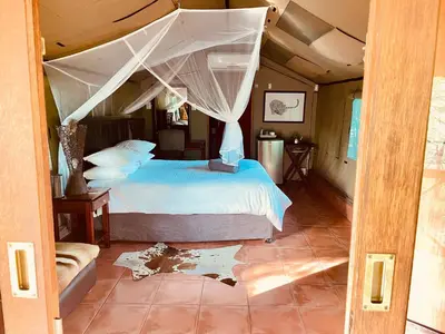 a bedroom with a bed with a canopy at Nyala Luxury Safari Tents in Marloth Park