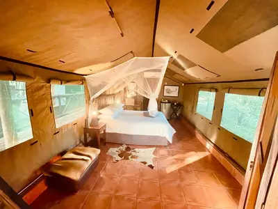 a bedroom with a bed and a couch in a room at Nyala Luxury Safari Tents in Marloth Park