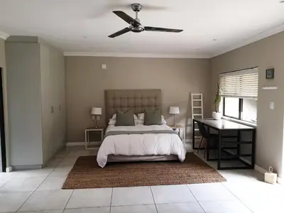 a bedroom with a bed and a ceiling fan at Studio's@360onChurch in Pretoria
