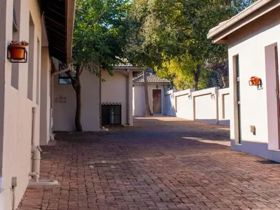 a cobblestone alley between two white buildings at Studio's@360onChurch in Pretoria