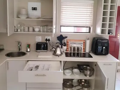 a kitchen with white cabinets and a sink at Studio's@360onChurch in Pretoria