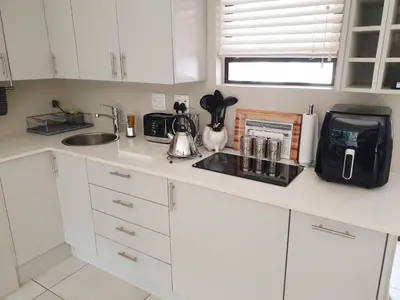 a kitchen with white cabinets and a counter top at Studio's@360onChurch in Pretoria