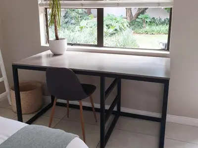 a desk with a chair in front of a window at Studio's@360onChurch in Pretoria