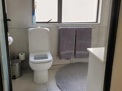 a small bathroom with a toilet and purple towels at Studio's@360onChurch in Pretoria