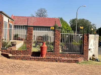 a brick building with a gate and a fire hydrant at Tranquil Haven in Kempton Park
