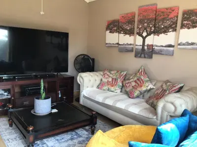 a living room with two couches and a flat screen tv at Tranquil Haven in Kempton Park