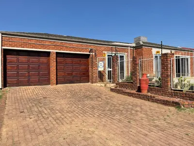 a brick house with two garage doors and a brick driveway at Tranquil Haven in Kempton Park