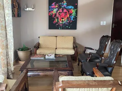 a living room with a couch and a table and chairs at Tranquil Haven in Kempton Park