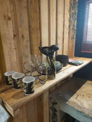 a wooden table with glasses and utensils on it at Vulture's View 8 in Hartbeespoort