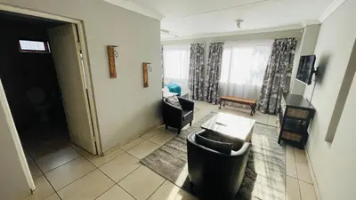 a living room with a couch and a table at Aspen Guest House NO LOADSHEDDING in Centurion