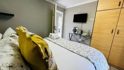 a bedroom with a bed and a television in it at Aspen Guest House NO LOADSHEDDING in Centurion