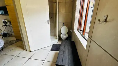 a small bathroom with a toilet and a window at Aspen Guest House NO LOADSHEDDING in Centurion