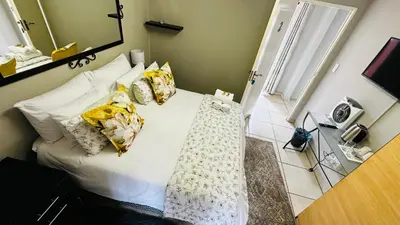 a bedroom with a bed with white sheets and pillows at Aspen Guest House NO LOADSHEDDING in Centurion