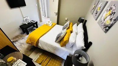 a bedroom with a bed with yellow sheets and pillows at Aspen Guest House NO LOADSHEDDING in Centurion