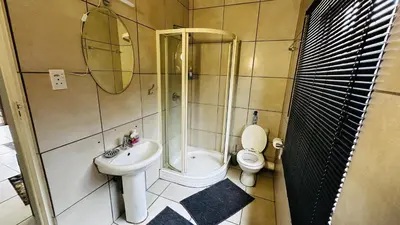a bathroom with a toilet and a sink and a shower at Aspen Guest House NO LOADSHEDDING in Centurion