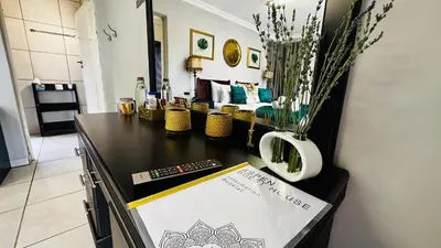 a room with a table with a sign and flowers at Aspen Guest House NO LOADSHEDDING in Centurion