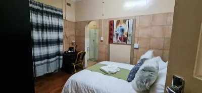 a bedroom with a bed with a cat laying on it at My House Guest House in Pretoria